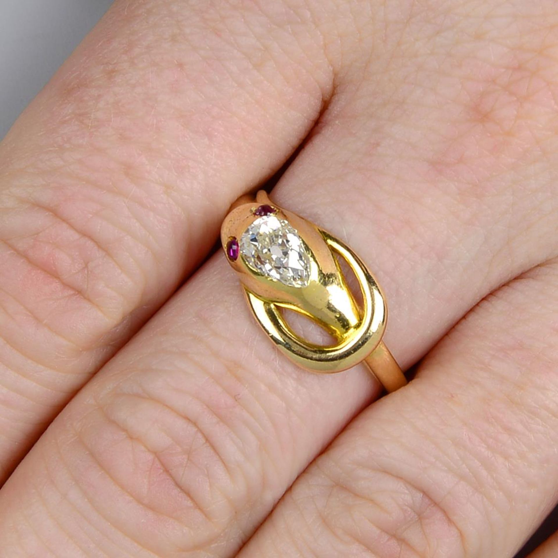 A late Victorian gold diamond and ruby snake ring.Estimated diamond weight 0.65ct,