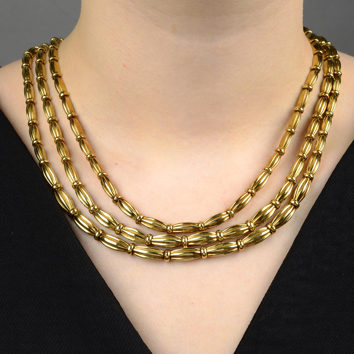 A grooved link, three-strand necklace, by Tiffany & Co.Stamped 750.