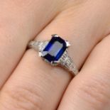 A sapphire single-stone ring, with pave-set diamond gallery and shoulders.
