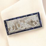 An Art Deco platinum, old-cut diamond phoenix motif brooch, with calibre-cut sapphire surround.