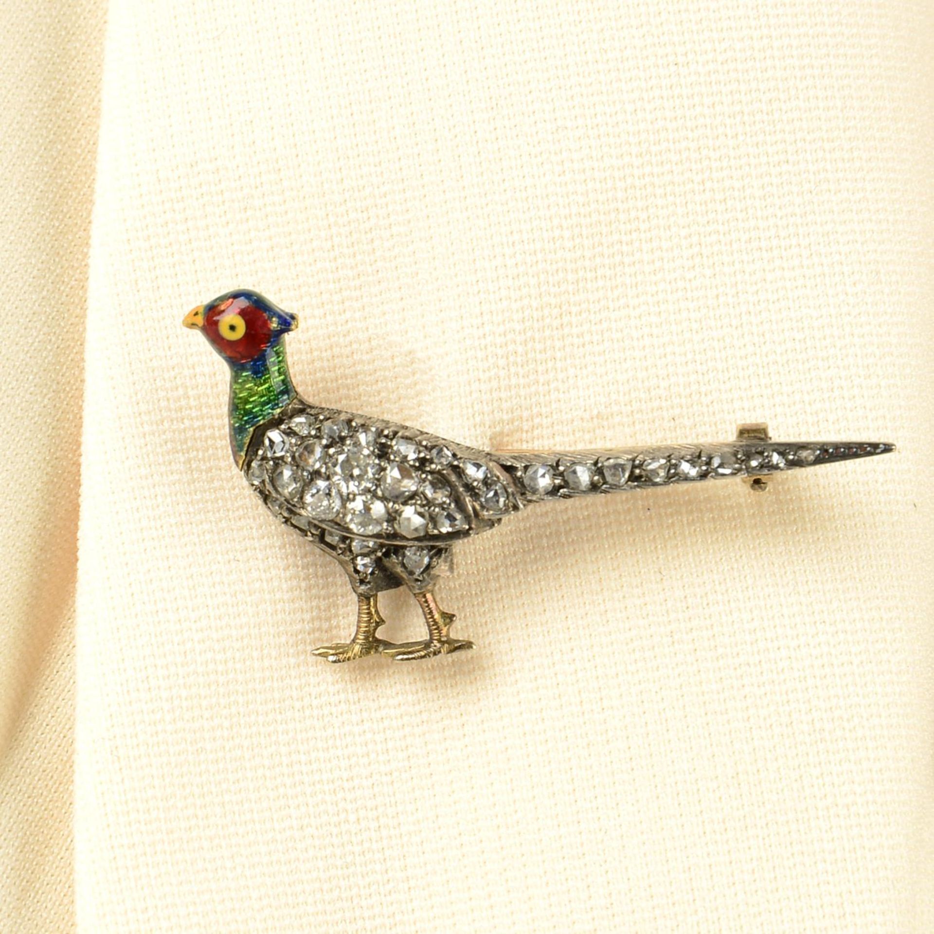 A late Victorian, silver and gold, pave-set diamond and enamel pheasant brooch.Length 3.9cms.