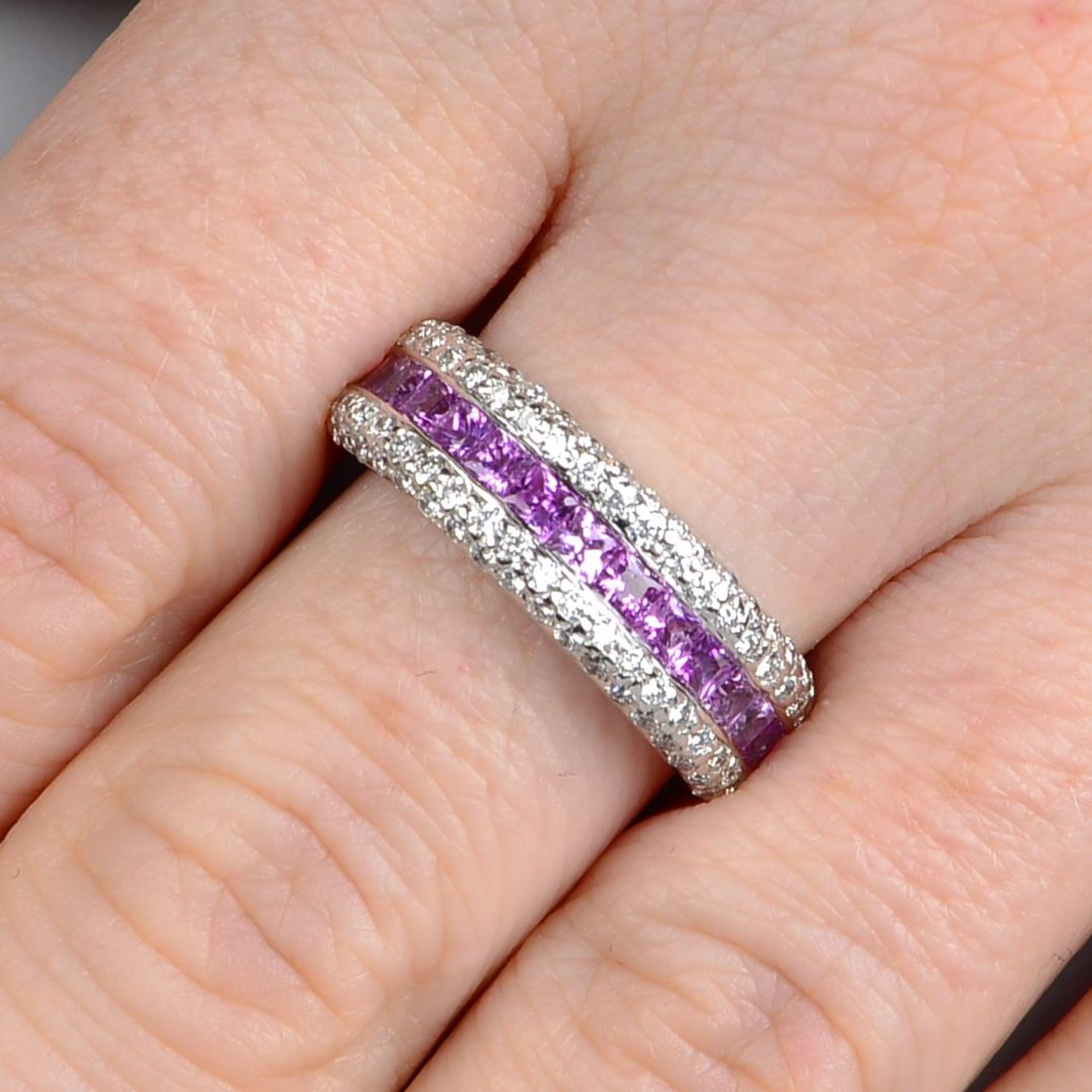 An 18ct gold square-shape pink sapphire half eternity ring, with pave-set diamond sides.