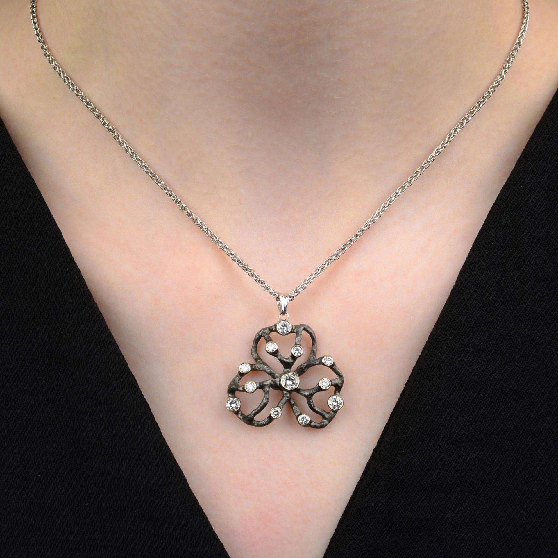 An 18ct gold brilliant-cut diamond stylised clover pendant, with spiga-link chain.