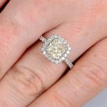 A cushion-shape diamond and brilliant-cut diamond cluster ring.