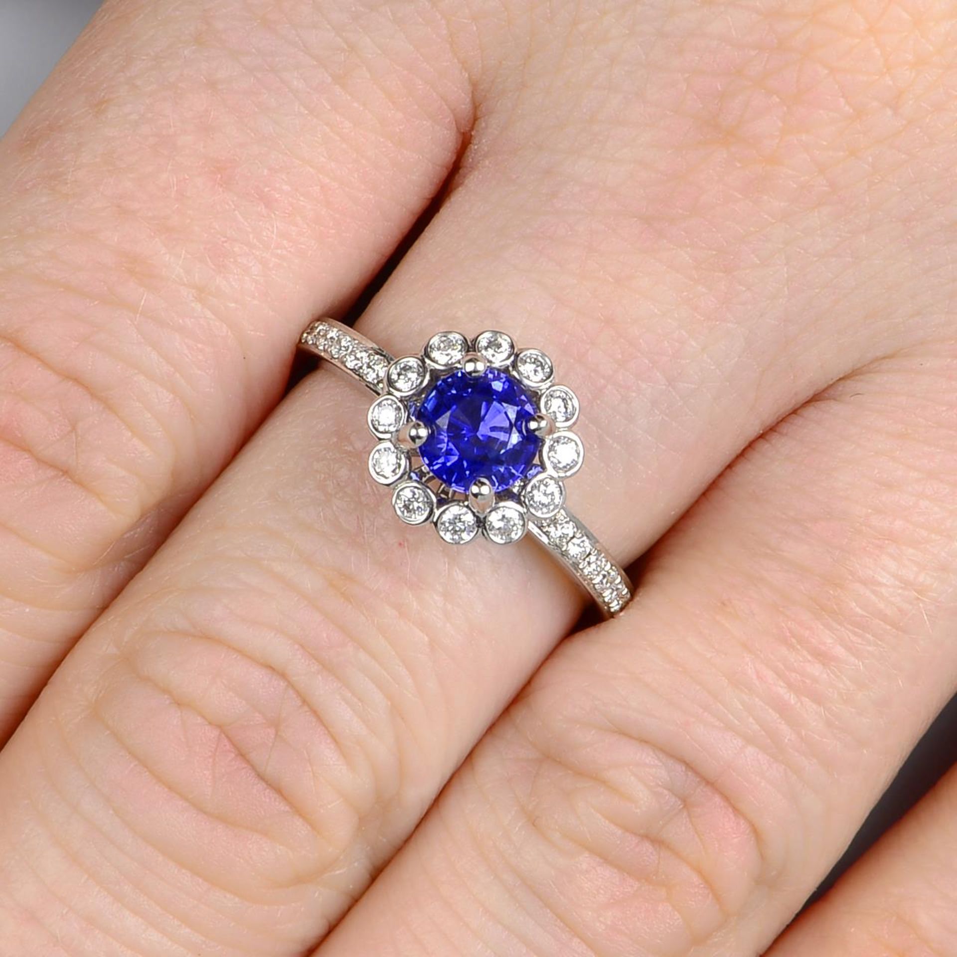 An 18ct gold sapphire and brilliant-cut diamond cluster ring.Sapphire estimated diameter