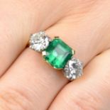 An 18ct gold emerald and diamond three-stone ring, with diamond accent gallery.