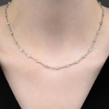 A brilliant-cut diamond collet line necklace.