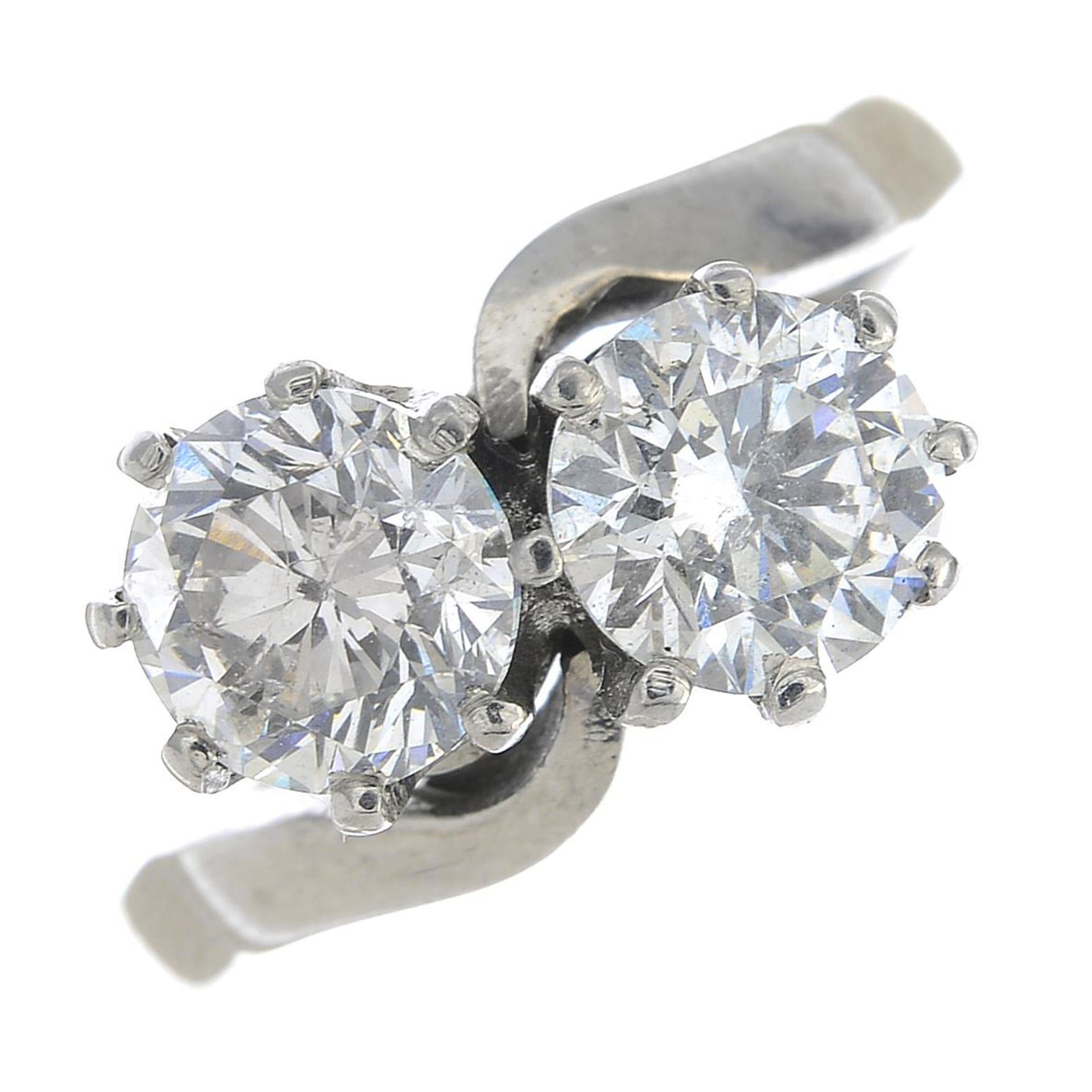 An 18ct gold brilliant-cut fracture-filled diamond two-stone crossover ring.Estimated total diamond