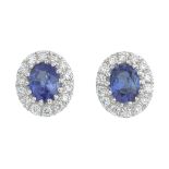 A pair of 18ct gold oval-shape sapphire and brilliant-cut diamond cluster earrings.Total sapphire