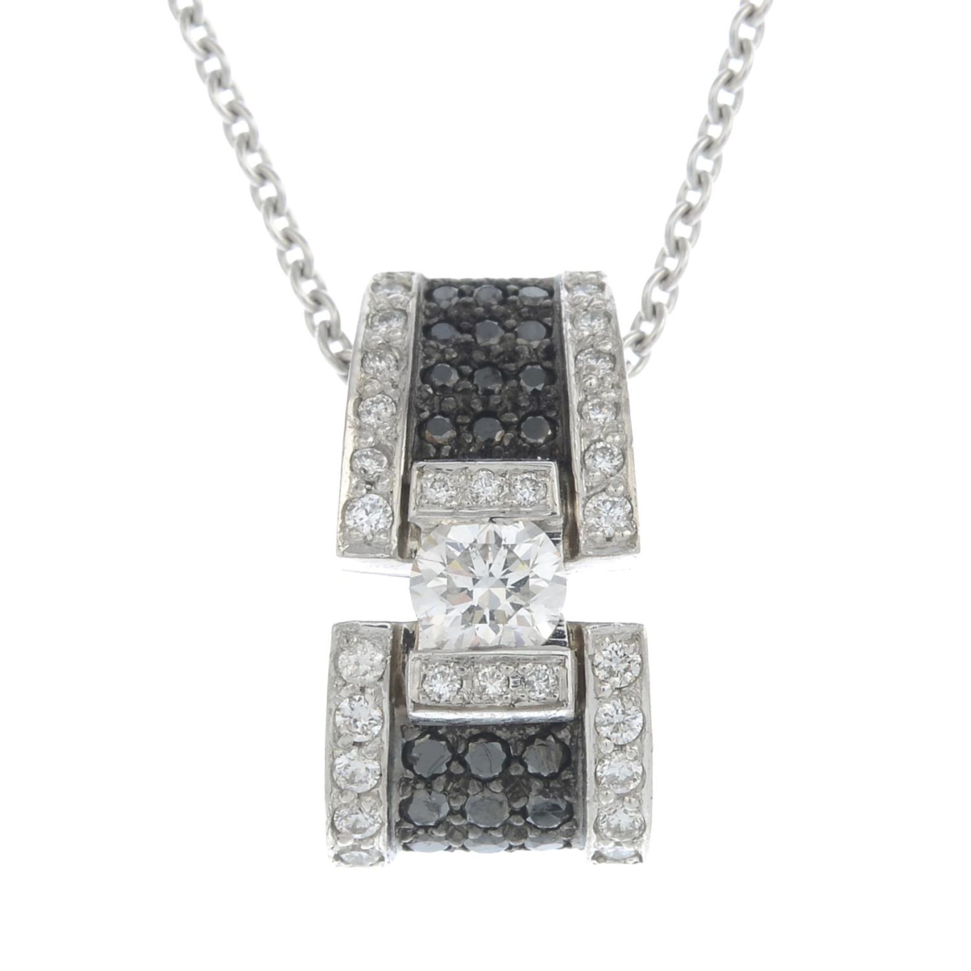 A brilliant-cut diamond and black gem pendant,