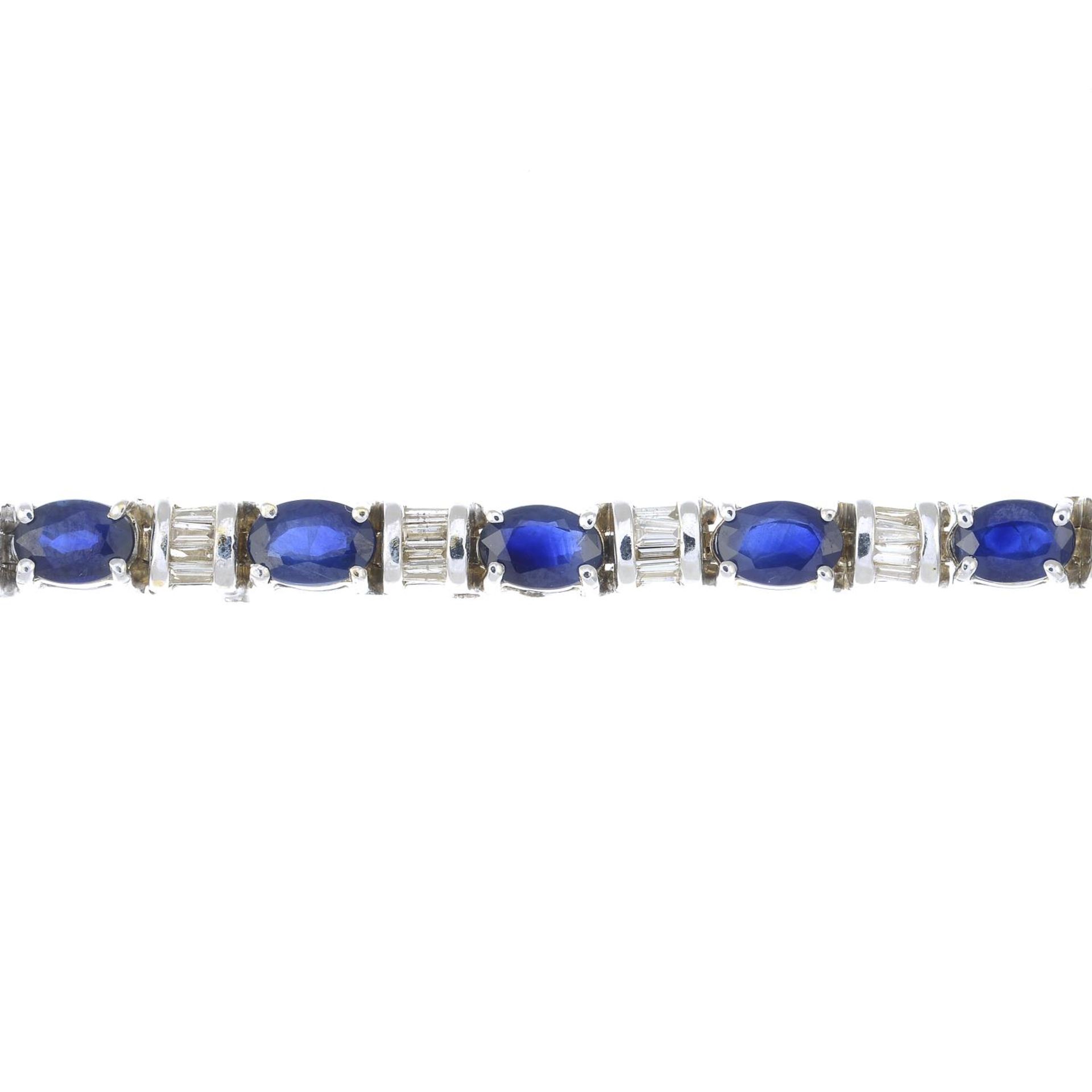 A 14ct gold sapphire and baguette-cut diamond line bracelet.Estimated total diamond weight