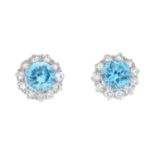 A pair of circular-shape blue zircon and brilliant-cut diamond cluster earrings.Total zircon weight
