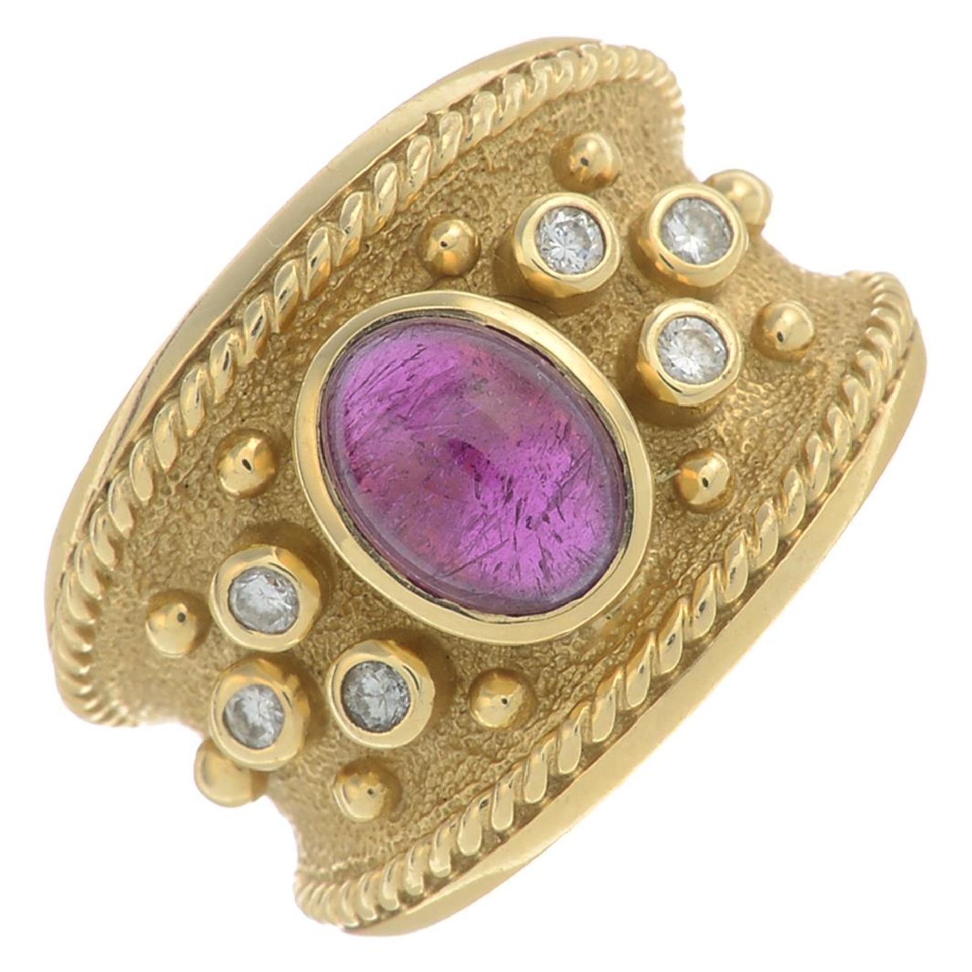 A garnet cabochon dress ring, with brilliant-cut diamond accents.