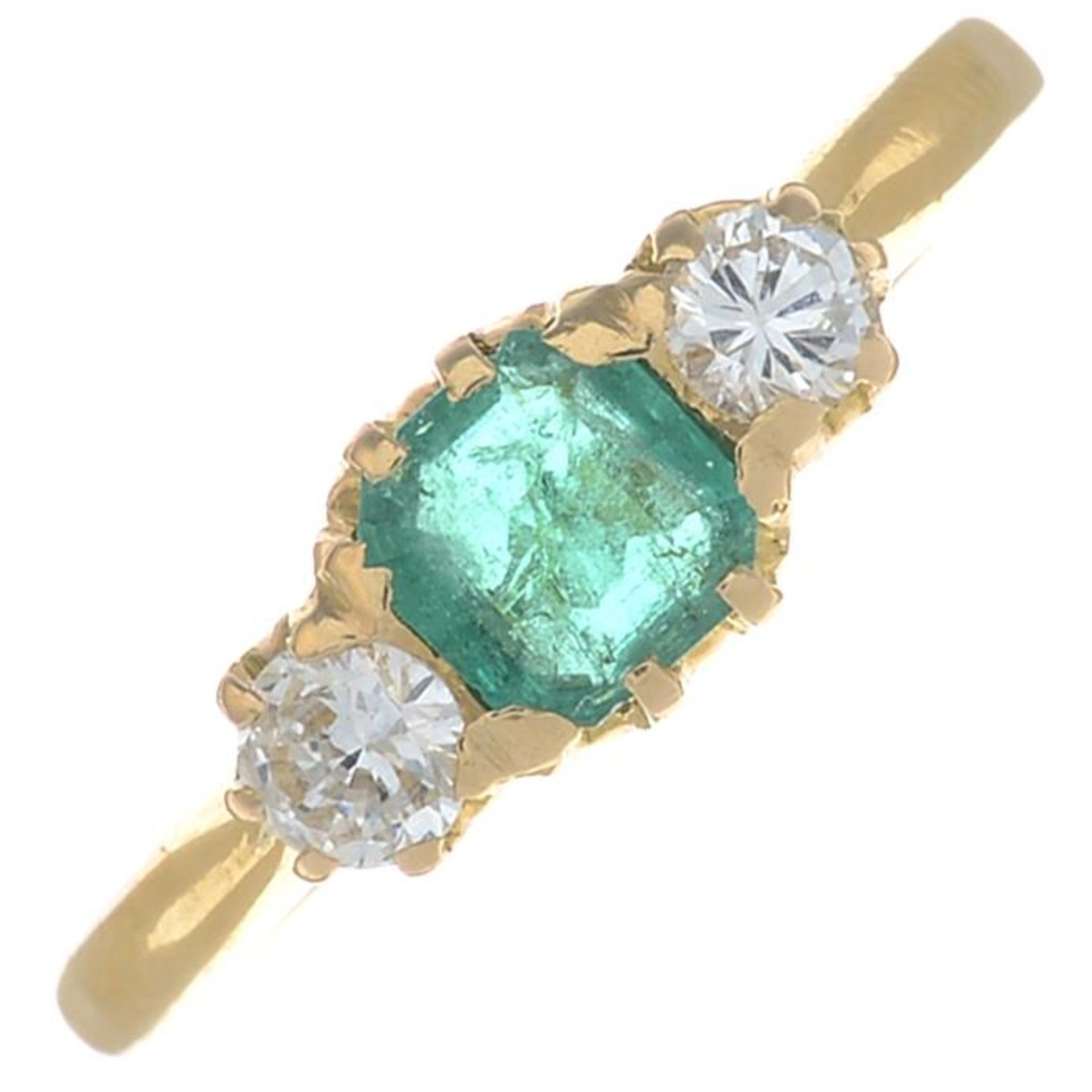 An emerald and brilliant-cut diamond three-stone ring.Emerald calculated weight 0.22ct,