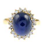 An oval sapphire cabochon and brilliant-cut diamond cluster ring.Estimated total diamond weight