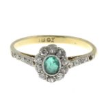 An emerald and diamond cluster ring.One diamond deficient.Estimated total diamond weight