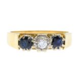 An 18ct gold diamond and sapphire three-stone ring.Estimated diamond weight 0.10ct,