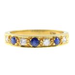 A diamond and sapphire seven-stone ring.Estimated total diamond weight 0.15ct.Stamped 18ct.Ring
