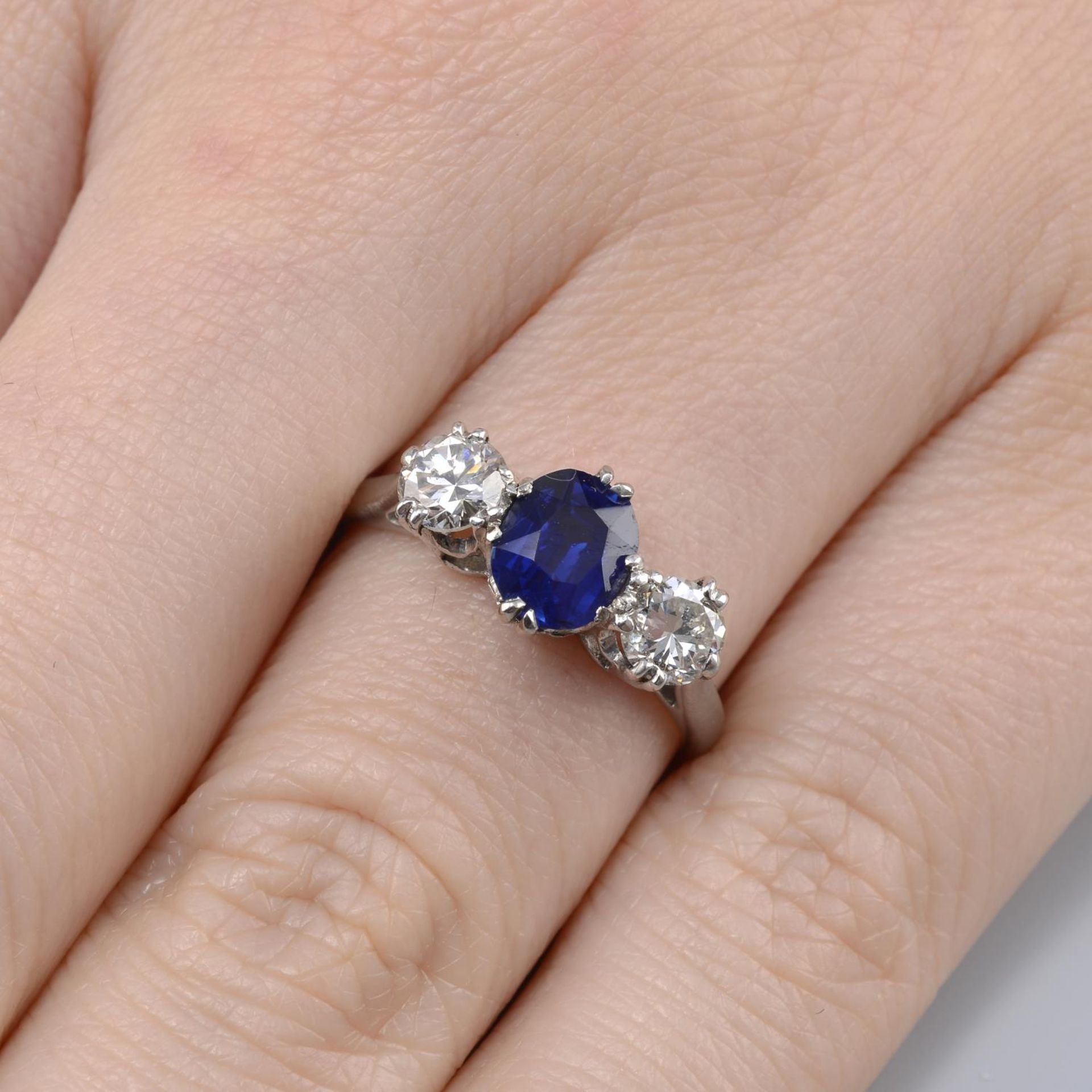 A sapphire and brilliant-cut diamond three-stone ring.Sapphire weight 1.12cts.Estimated total