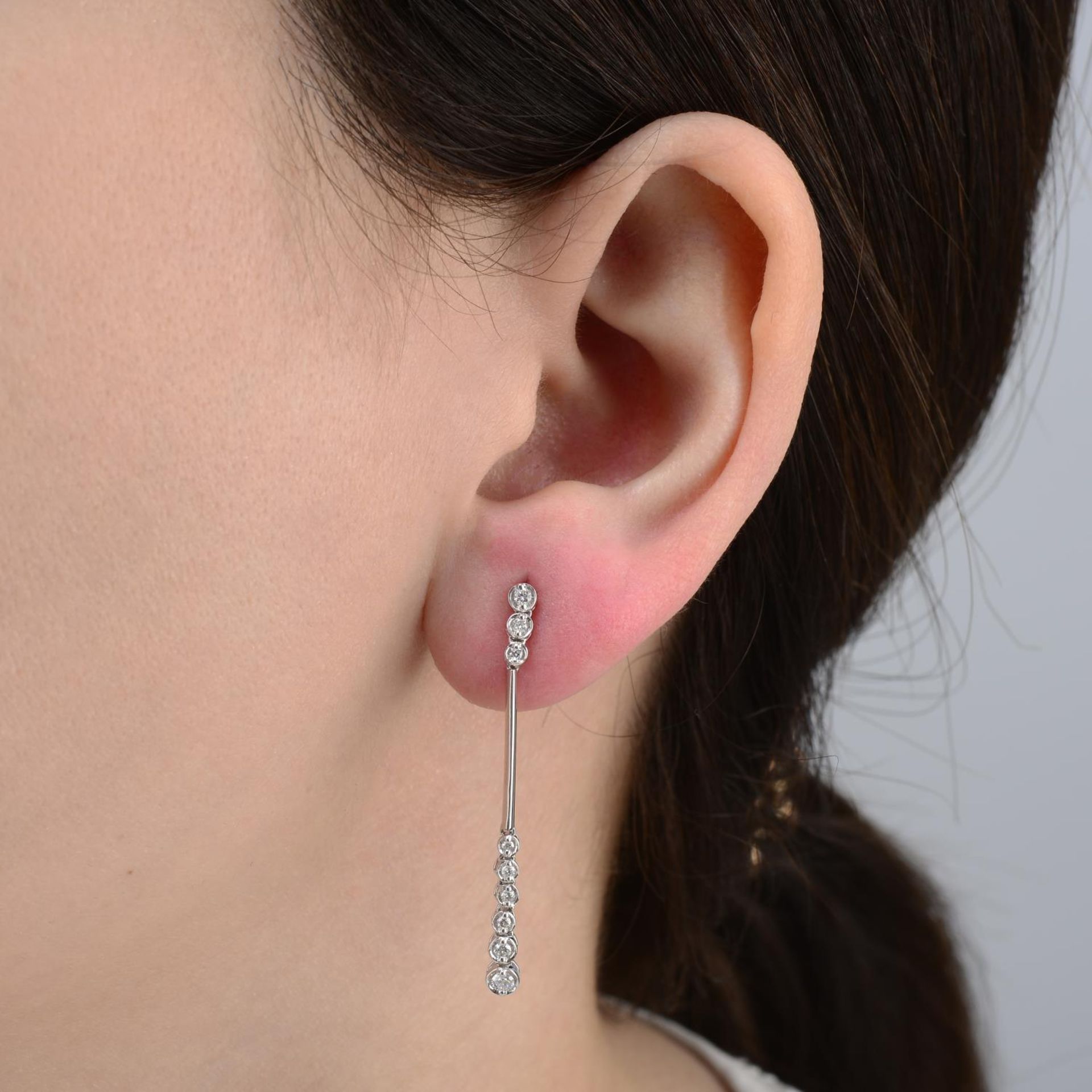 A pair of brilliant-cut diamond drop earrings.Total diamond weight 0.25cts,