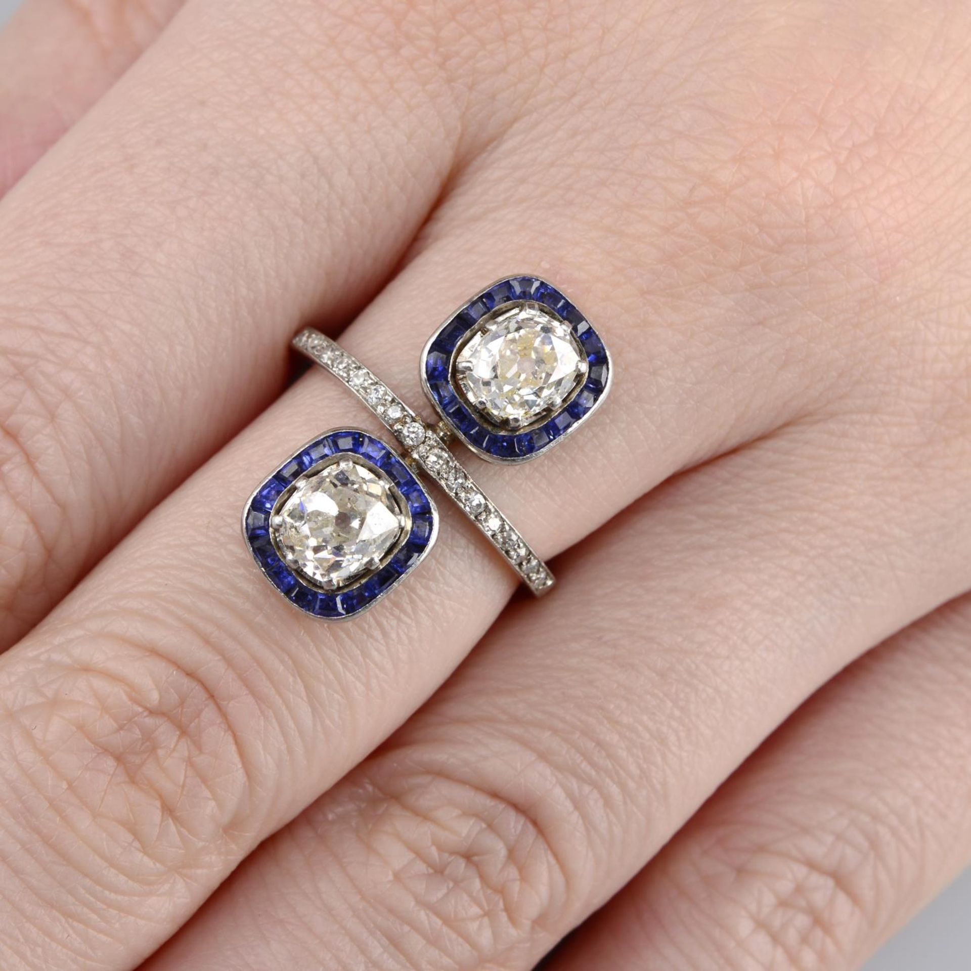 A mid 20th century old-cut diamond and calibre-cut sapphire twin cluster ring.Principal diamonds