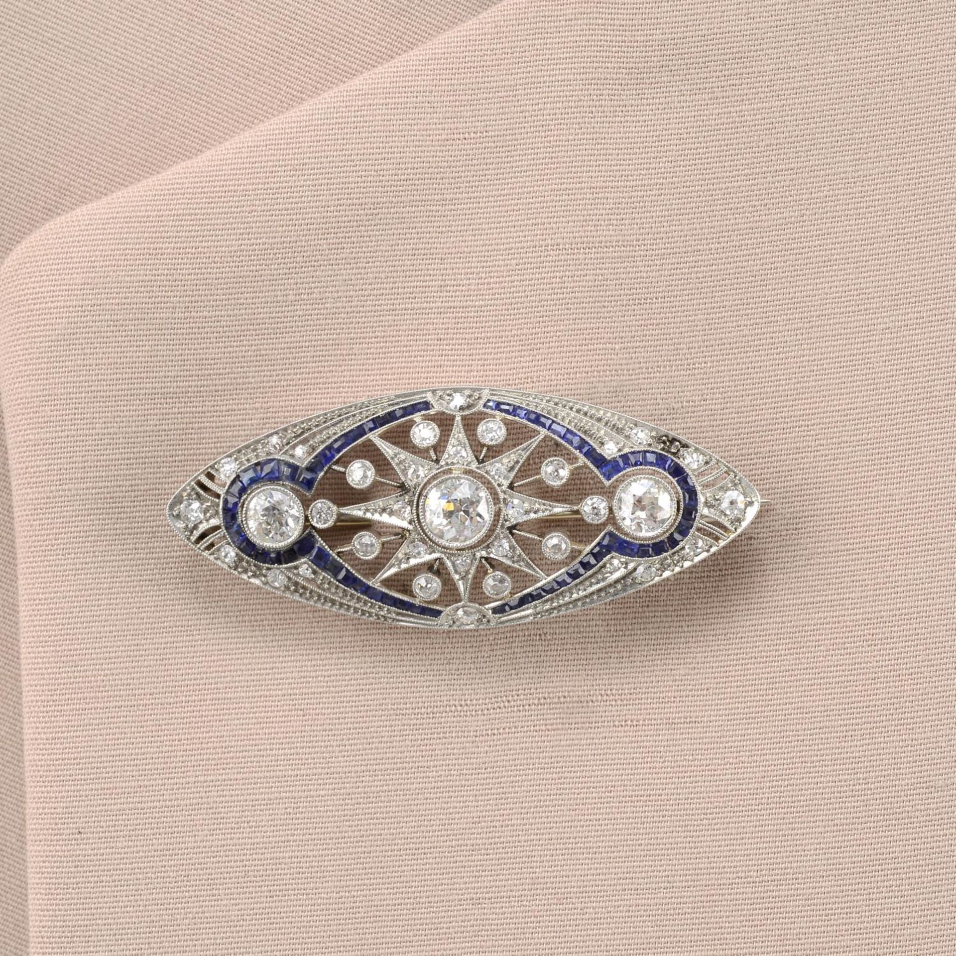 An old-cut diamond and calibre-cut sapphire openwork brooch.