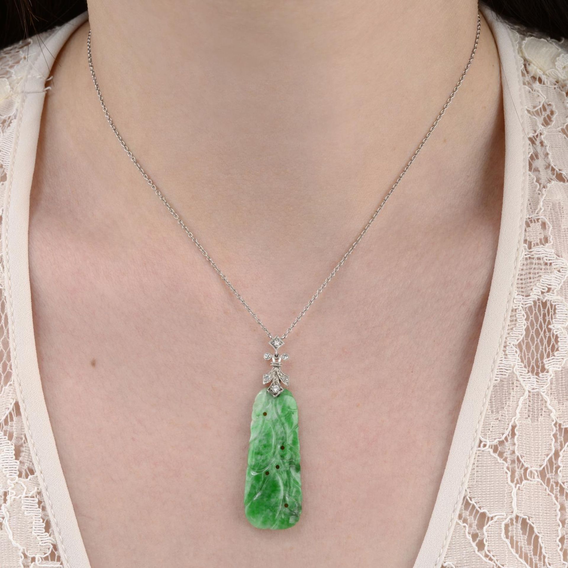 An early 20th century carved jadeite and vari-cut diamond pendant,