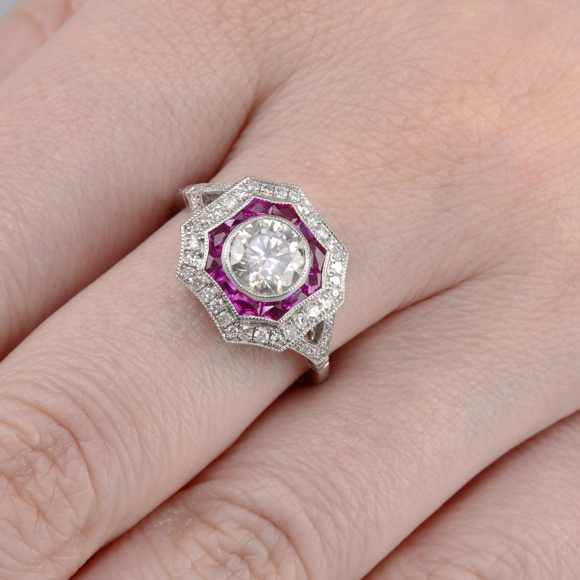 A brilliant-cut diamond and ruby dress ring.Principal diamond estimated weight 0.80ct,