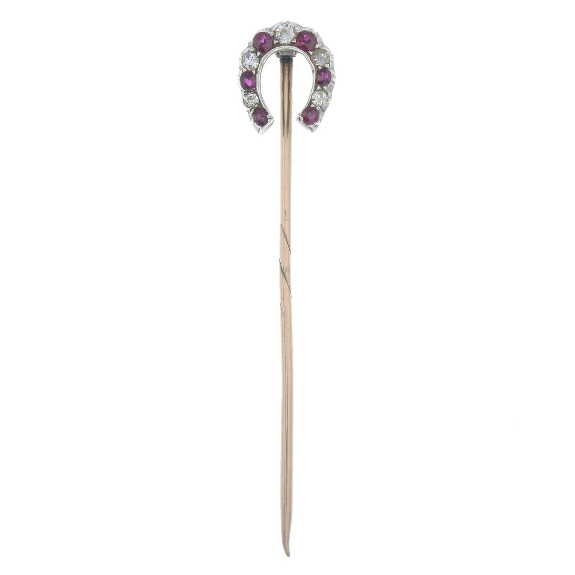 A late 19th century silver and gold ruby and diamond horseshoe stickpin.Estimated total diamond