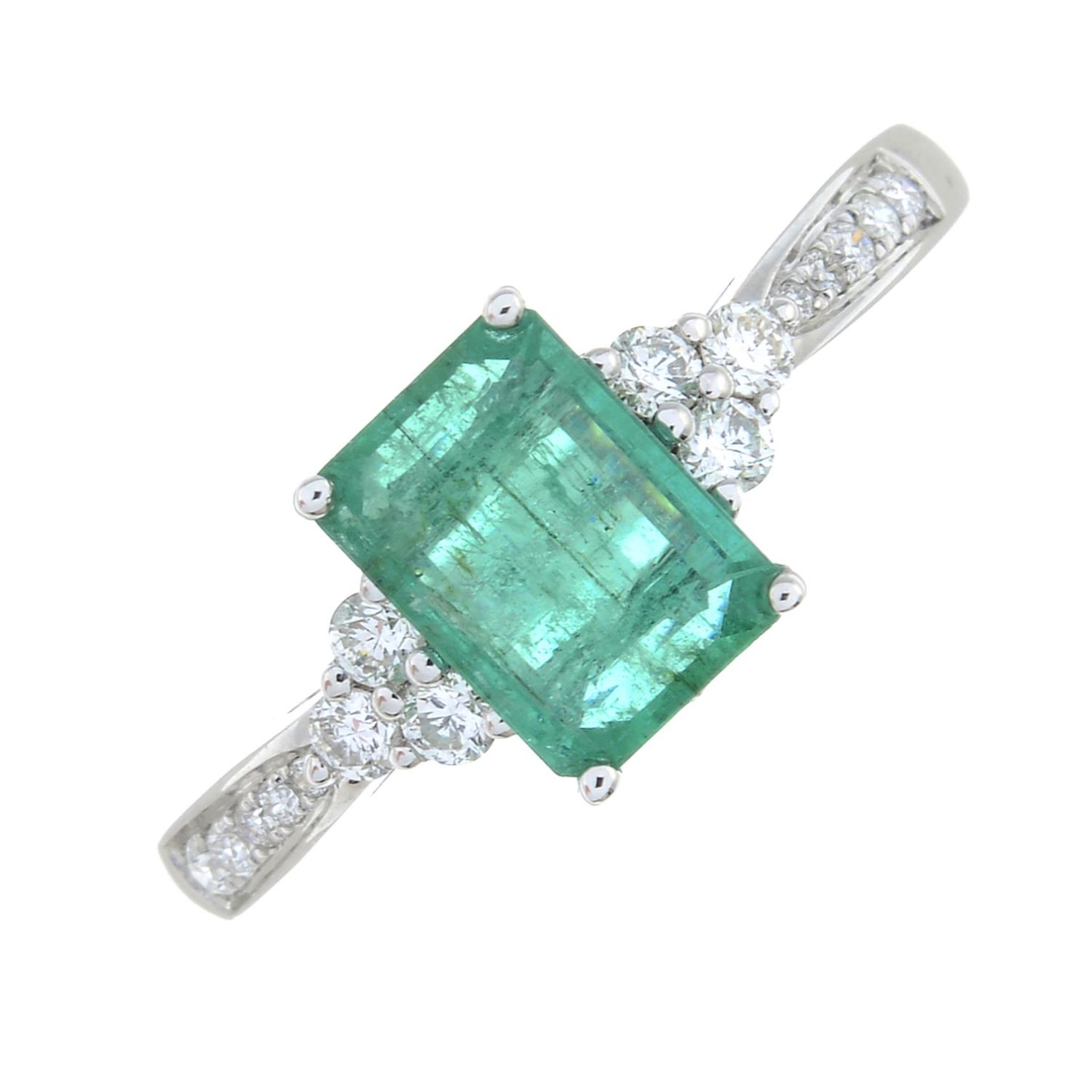 An emerald ring, with brilliant-cut diamond sides.