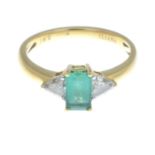 An 18ct gold emerald and diamond three-stone ring.Estimated total diamond weight 0.45ct,