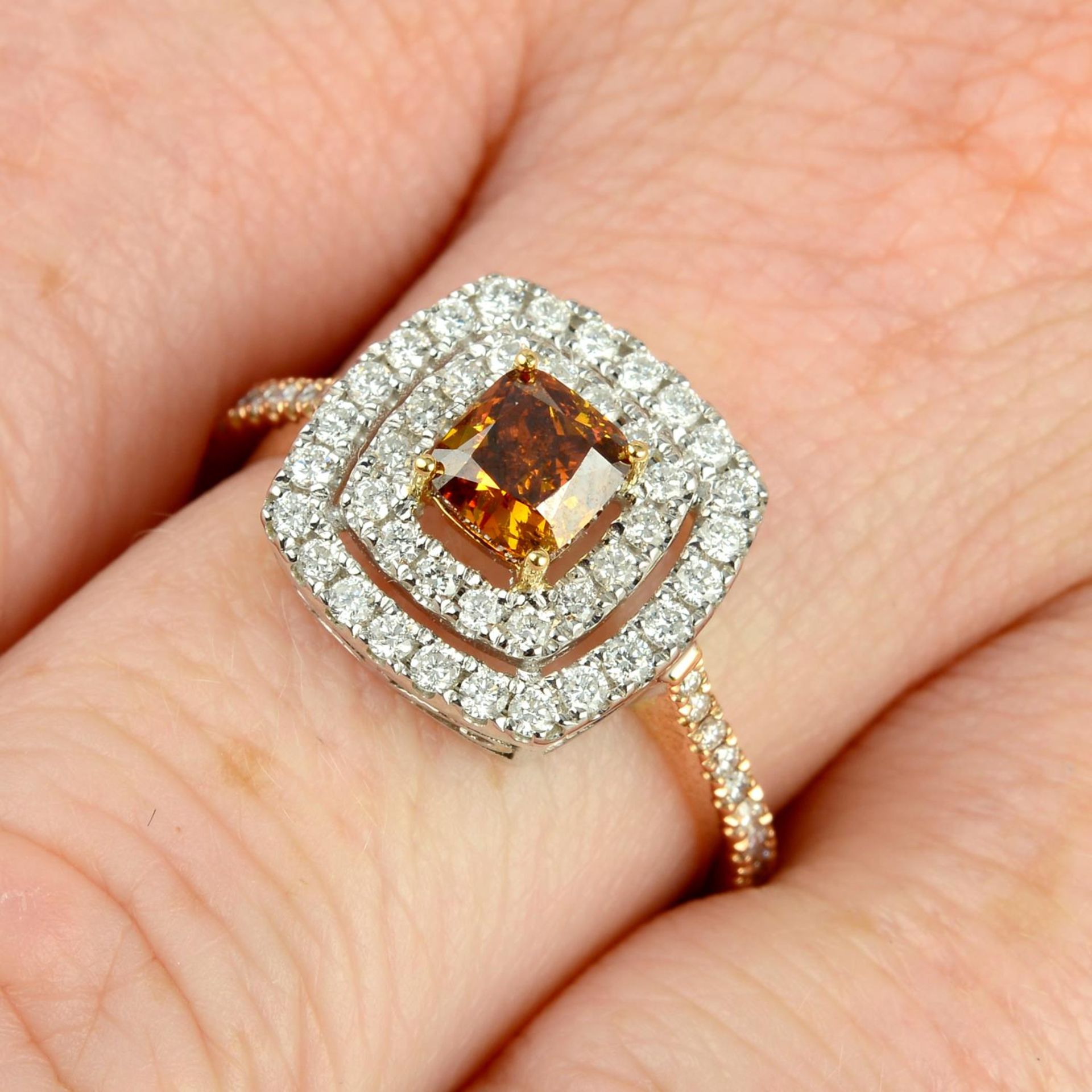 A bi-colour 18ct gold 'orangey brown' diamond and diamond dress ring.Principal diamond weight