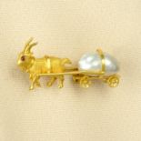 An early 20th century gold pearl and ruby brooch, designed as a goat pulling a cart.