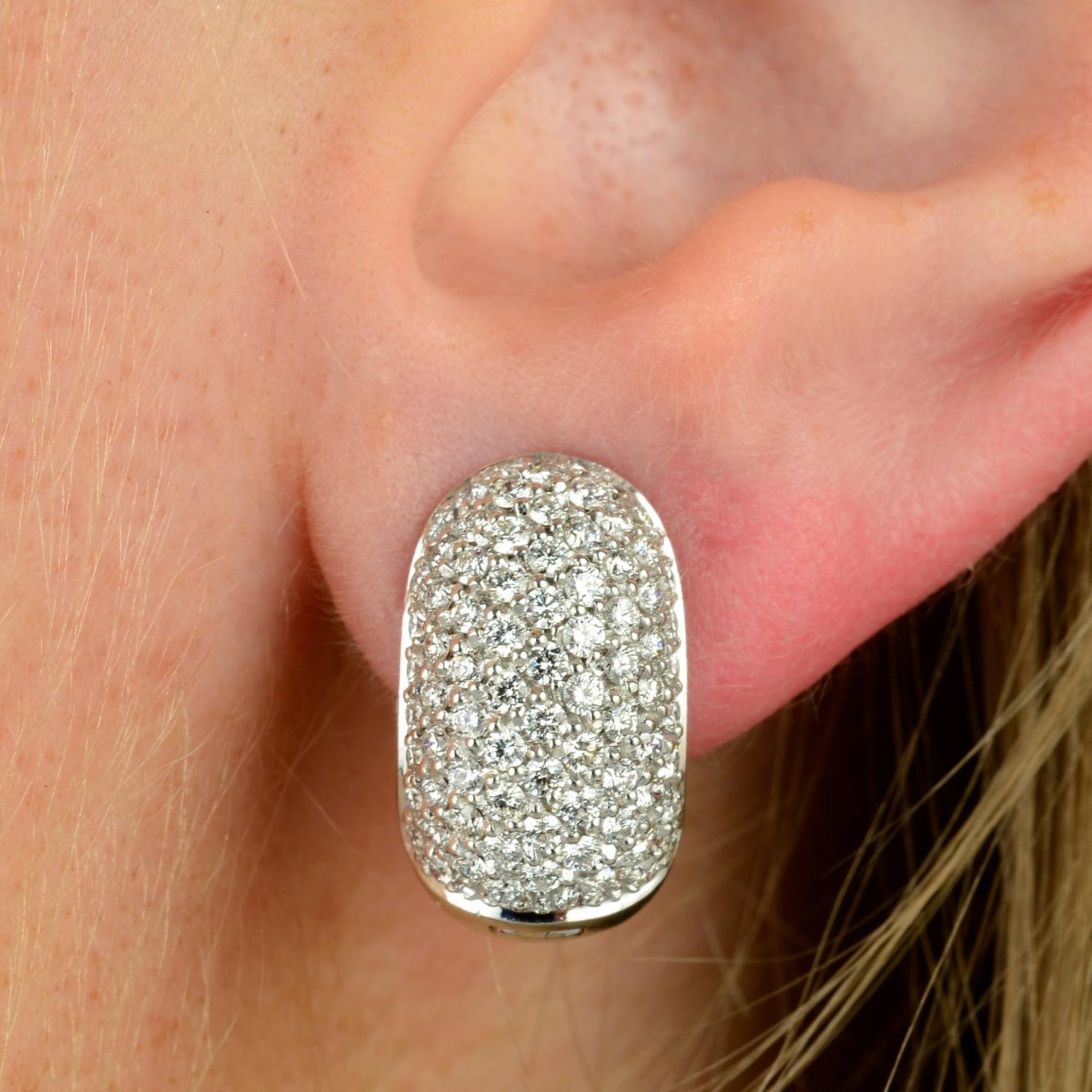 A pair of pave-set diamond hinged hoop earrings.Estimated total diamond weight 1.50cts,