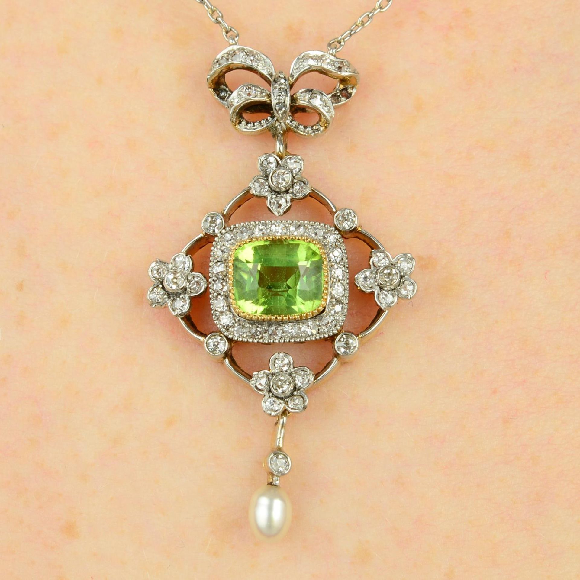An early 20th century platinum and gold, peridot, old-cut diamond and pearl pendant, on chain.
