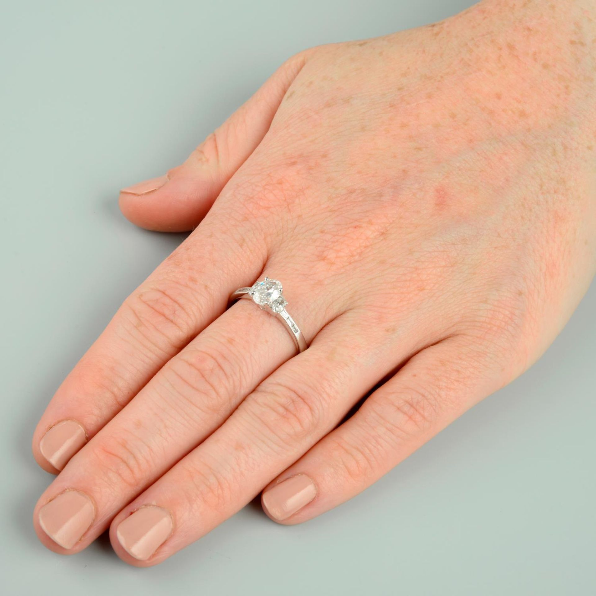 An oval-shape diamond single-stone ring, with oval-shape and baguette-cut diamond sides. - Bild 3 aus 6