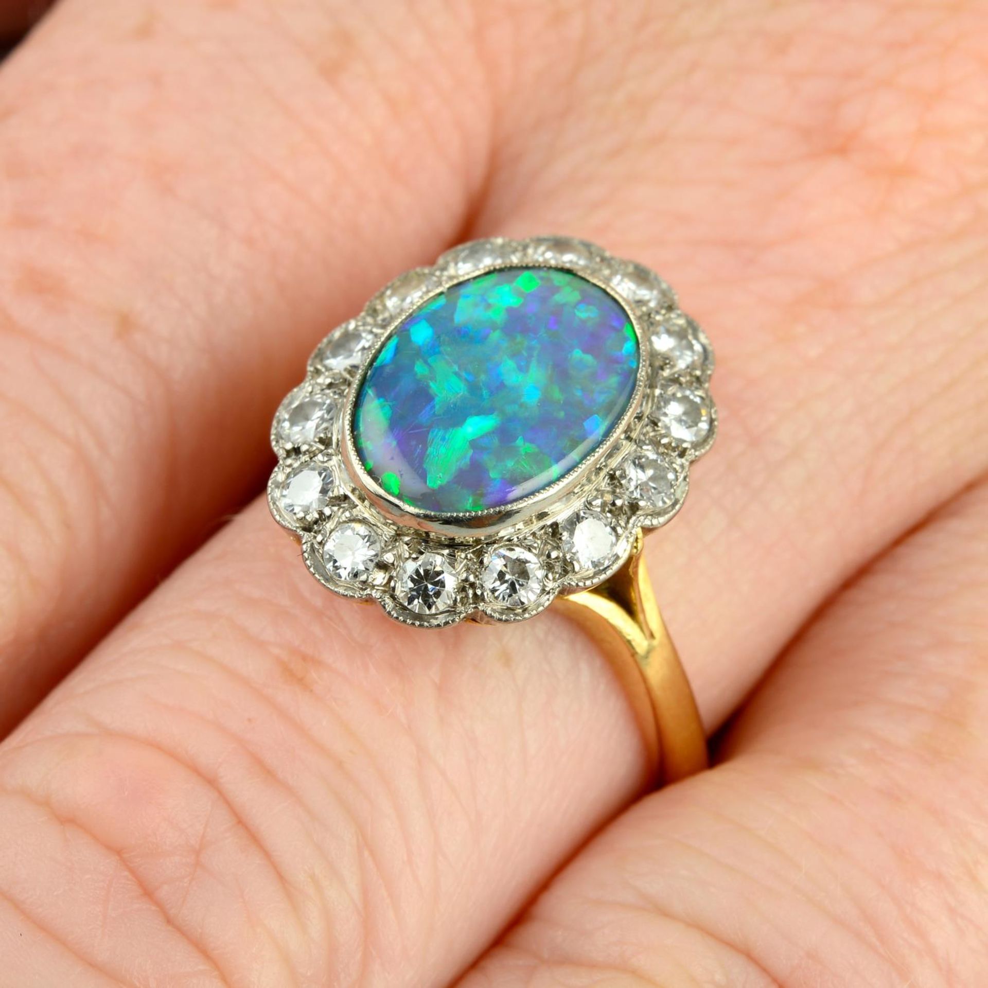 A mid 20th century 18ct gold black opal and brilliant-cut diamond cluster ring.Opal calculated