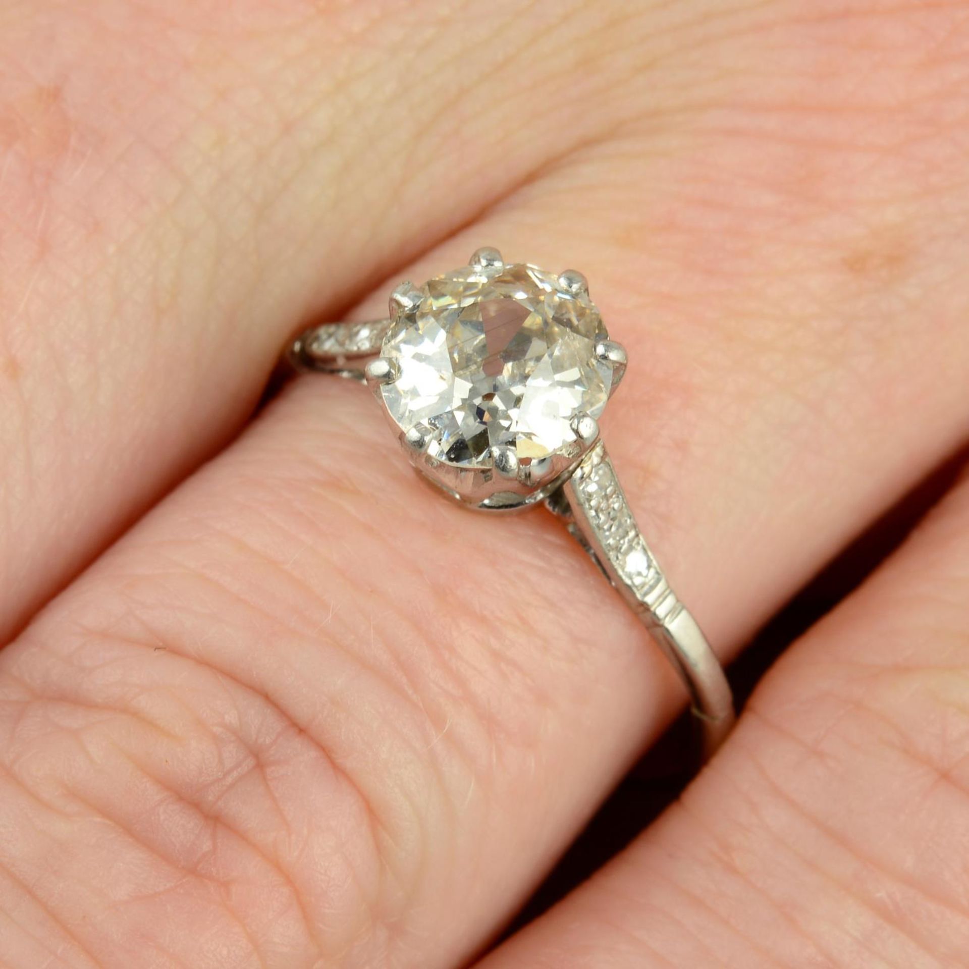 An old-cut diamond single-stone ring, with diamond shoulders.