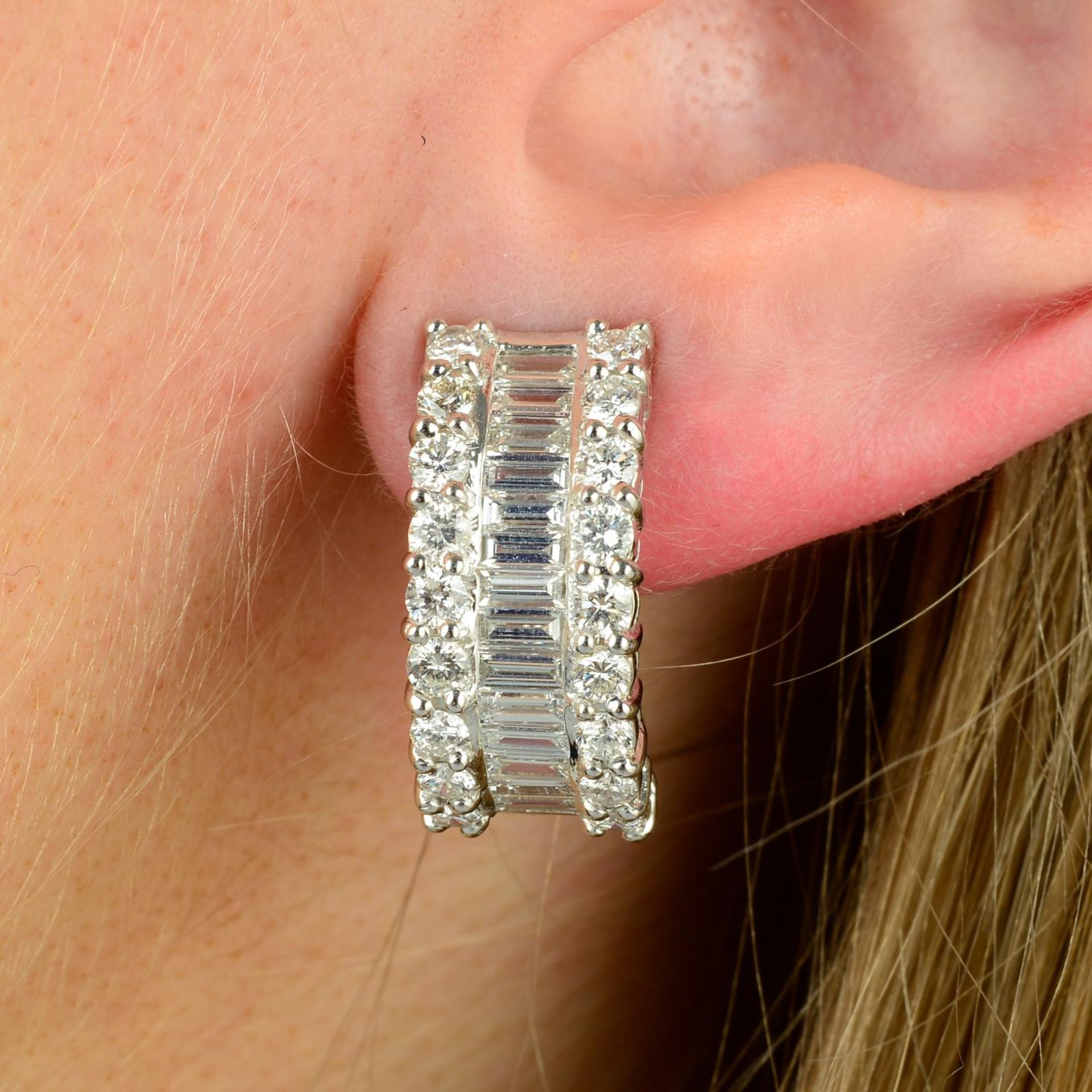 A pair of 18ct gold baguette and brilliant-cut diamond half hoop earrings.Total diamond weight