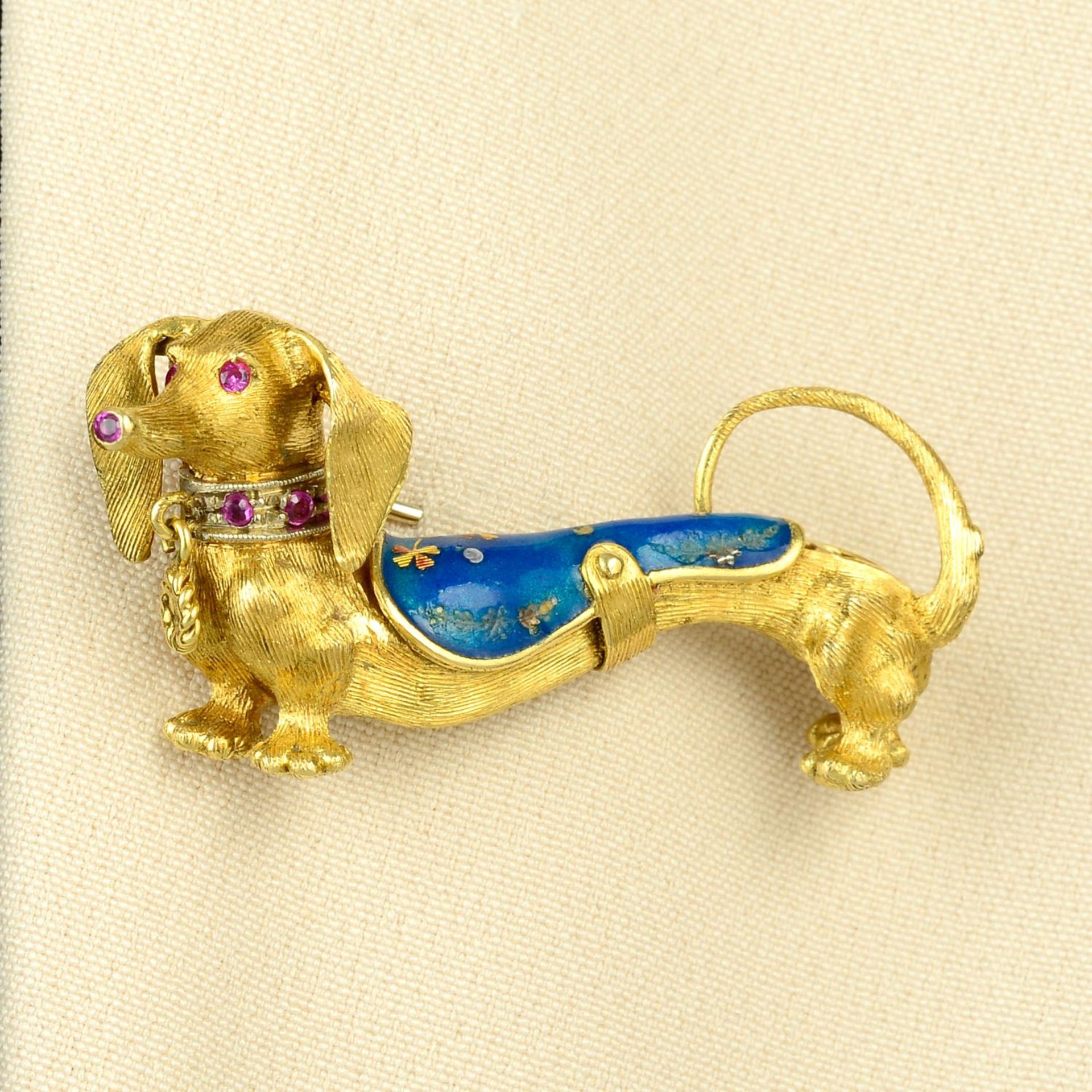 A mid 20th century gold dachshund dog brooch, with enamel coat and ruby highlights.