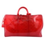 LOUIS VUITTON - a Vinyl Grenadine Red Monogram Keepall Bandoulière 50 luggage bag.