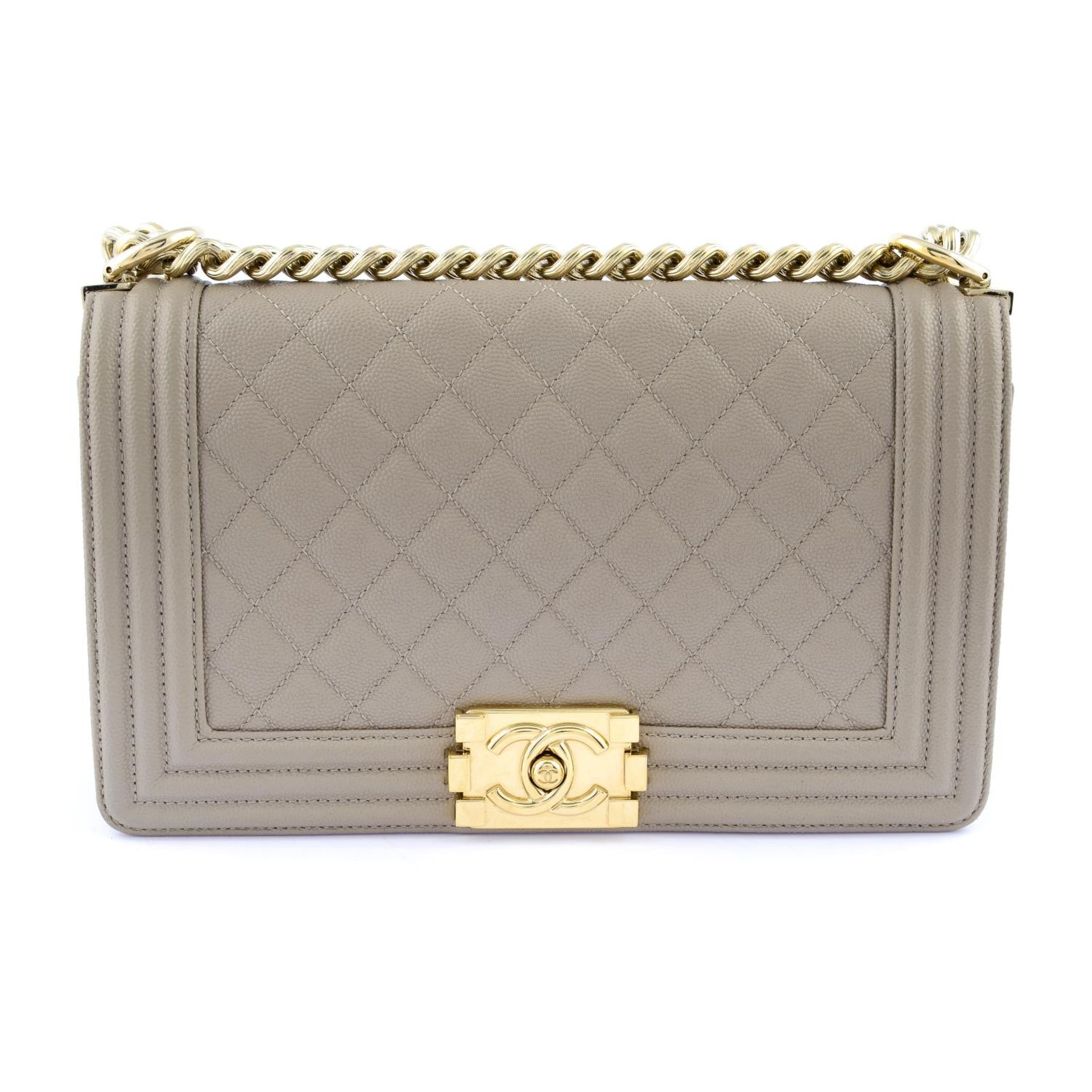 CHANEL - a Medium Shiny Beige Caviar Boy Flap handbag.