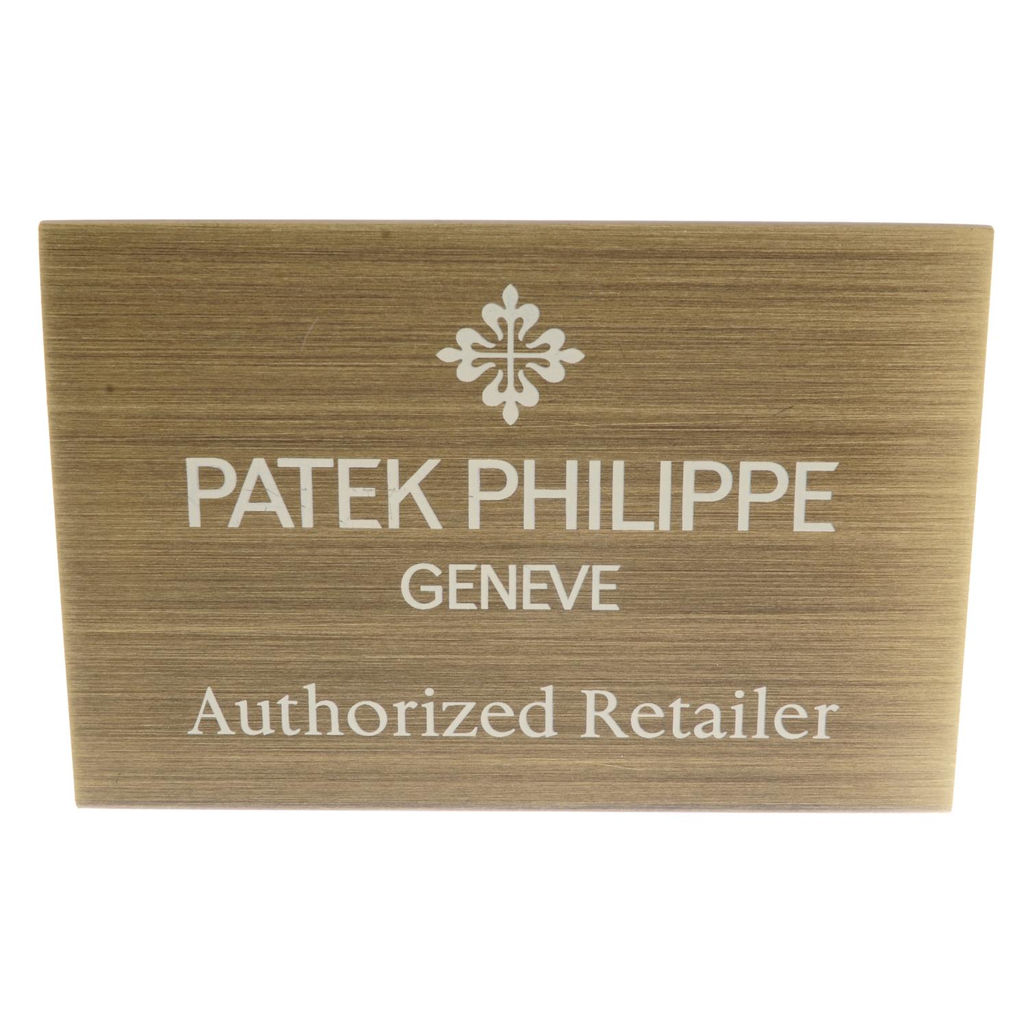 PATEK PHILIPPE - a brass 'Authorized Retailer' display sign.