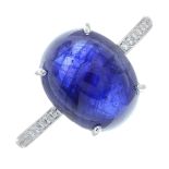 An 18ct gold glass-filled sapphire cabochon and brilliant-cut diamond ring.Sapphire calculated
