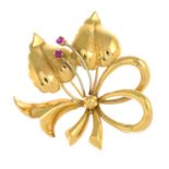 A floral brooch, with red gem highlights.