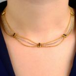 An 18ct gold bi-colour necklace, with garnet spacers, by Cartier.