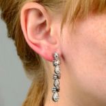 A pair of pavé-set diamond drop earrings.