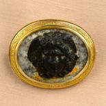 A mid to late Victorian gold carved hardstone cameo brooch, carved to depict winged Medusa.