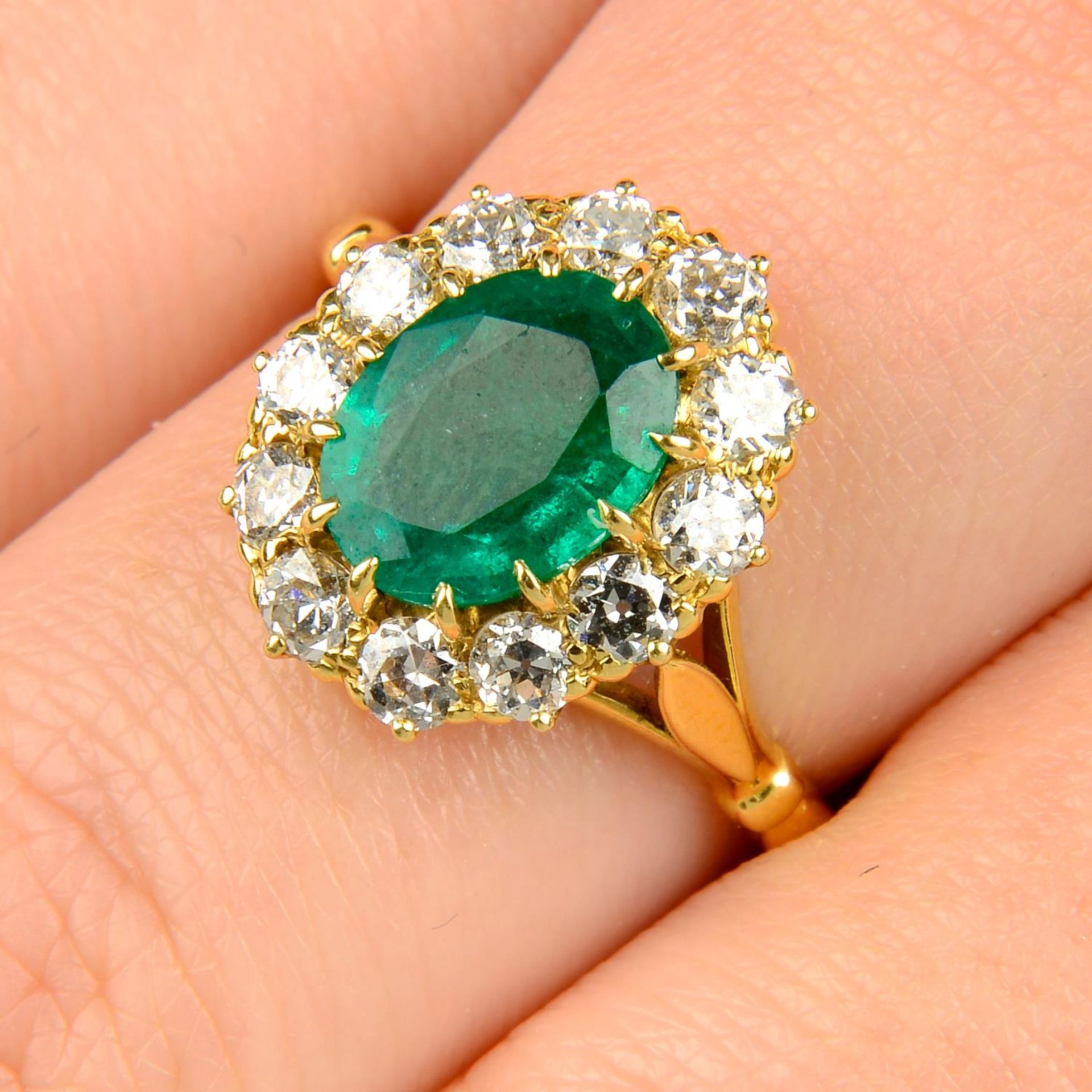 An emerald and old-cut diamond cluster ring.