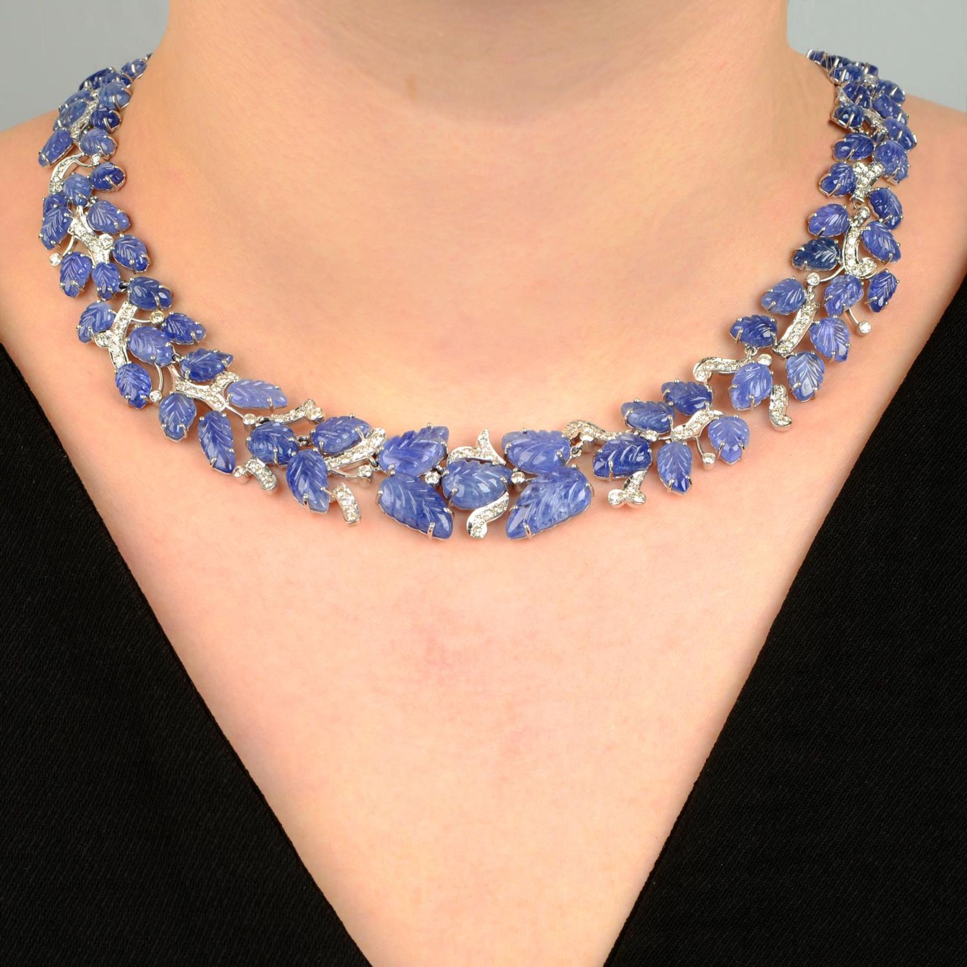 A foliate-carved sapphire and brilliant-cut diamond necklace.Estimated total diamond weight